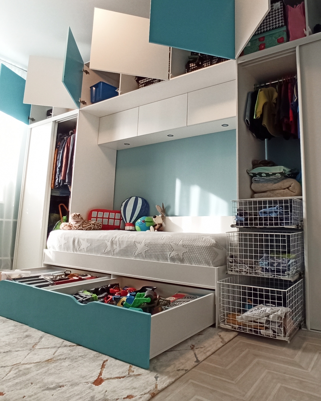 Кровать с выдвижными ящиками и продуманная стенка для хранения вещей ребенка в детской от Финист Терра