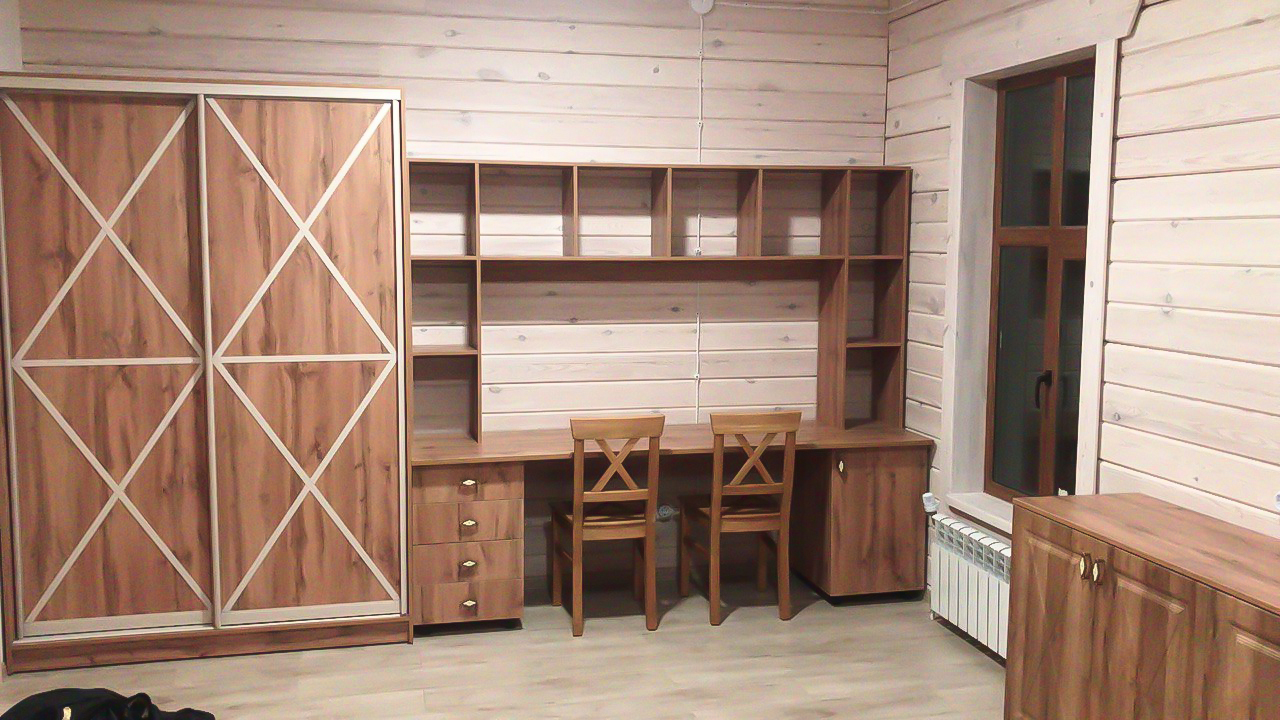 Рабочий стол для двоих детей вдоль стены с шкафом