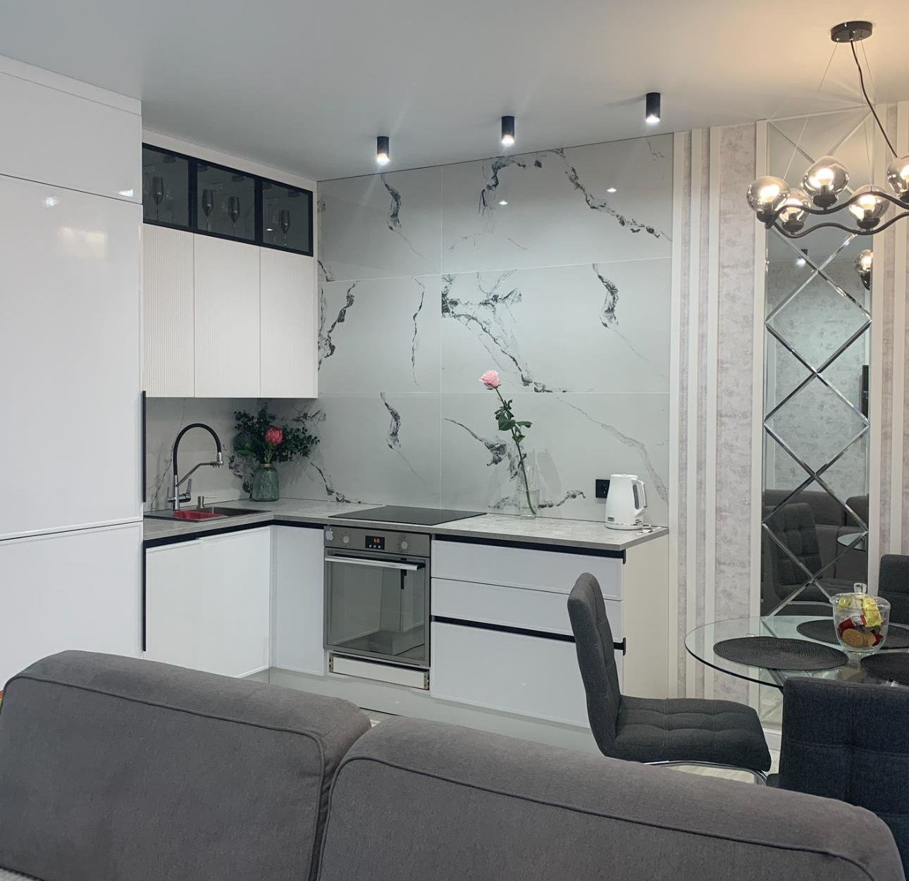 Светлый минималистичный кухонный гарнитур по индивидуальным размерам на заказ в совмещенной кухне с гостиной